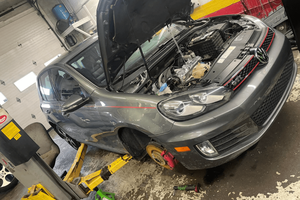 car warning signs, auto repair in Hanover, PA at Alex's Autoworks. Gray Volkswagen GTI on a lift in an auto repair shop with its hood open.