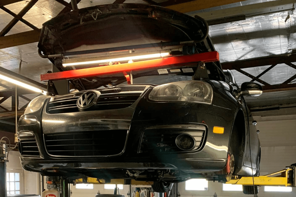 routine car maintenance, auto repair in Hanover, PA at Alex's Autoworks. Volkswagen on a lift inside an auto repair shop.
