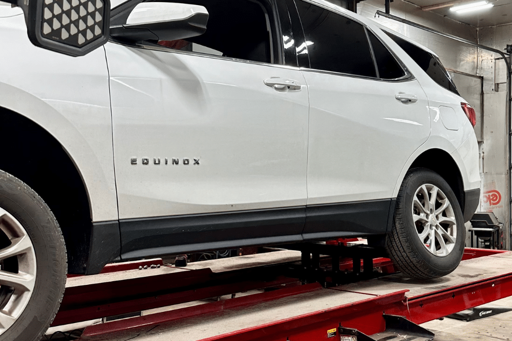 Chevy Equinox positioned on a red alignment rack, undergoing precision wheel alignment service by Alex’s Autoworks in Hanover, PA.
