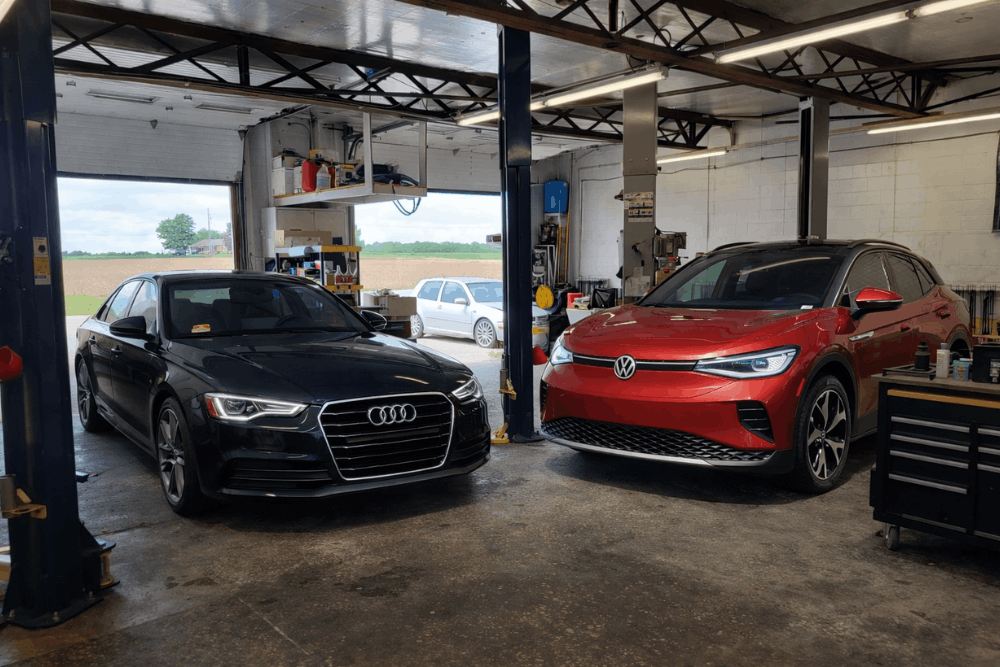 Audi and VW specialist, auto repair in Hanover, PA by Alex’s Autoworks. Image of an Audi sedan and Volkswagen SUV inside a professional service bay. Demonstrating precision maintenance, advanced diagnostics, and a commitment to vehicle performance and driver safety.