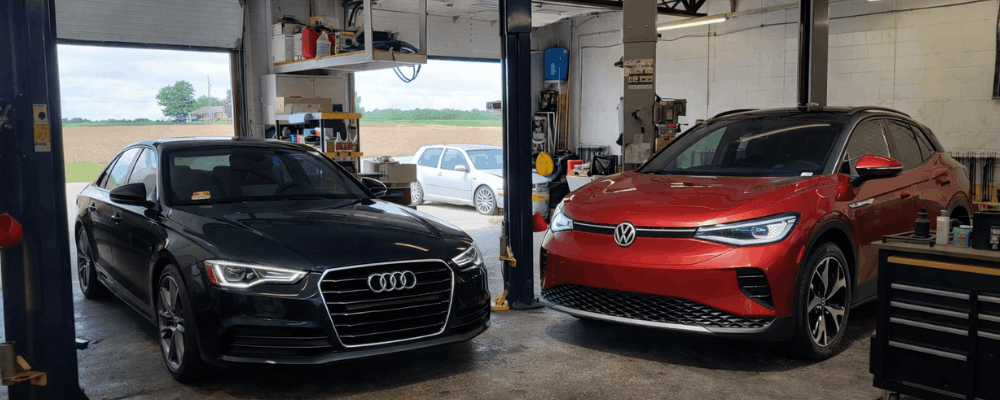 Audi and VW specialist, auto repair in Hanover, PA by Alex’s Autoworks. Image of an Audi sedan and Volkswagen SUV inside a professional service bay. Demonstrating precision maintenance, advanced diagnostics, and a commitment to vehicle performance and driver safety.