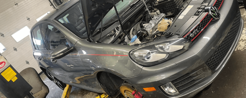 car warning signs, auto repair in Hanover, PA at Alex's Autoworks. Gray Volkswagen GTI on a lift in an auto repair shop with its hood open.