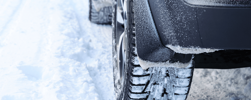 Tire repair and replacement in Hanover, PA by Alex’s Autoworks. Image of a vehicle’s rear tire gripping snowy terrain, showing deep tread patterns designed for improved traction, stability, and safer handling during harsh winter driving conditions.
