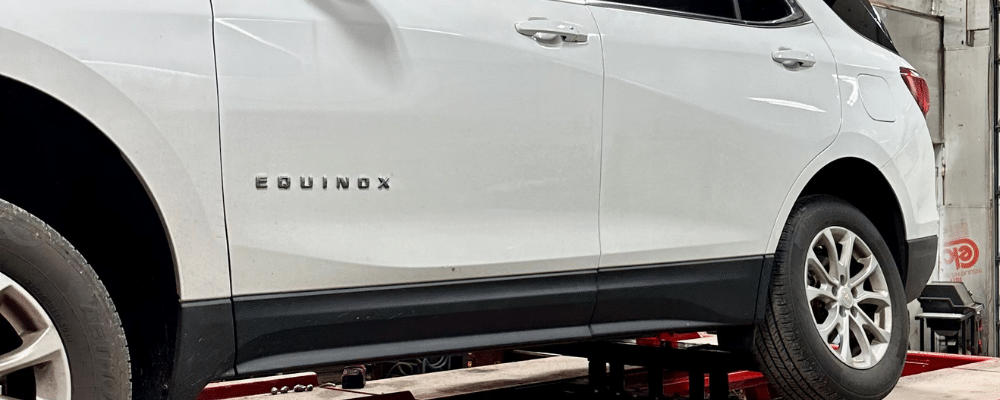 Chevy Equinox positioned on a red alignment rack, undergoing precision wheel alignment service by Alex’s Autoworks in Hanover, PA.